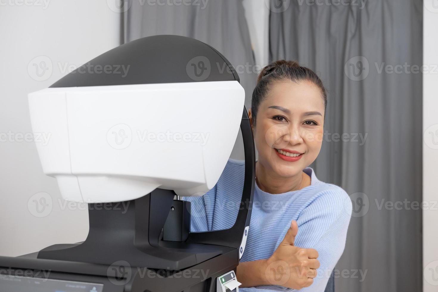 Elder Asian women at the Optometry equipment. While optometrist using subjective refraction to  examine eye visual system of elder patient women with professional machine before made glasses. photo