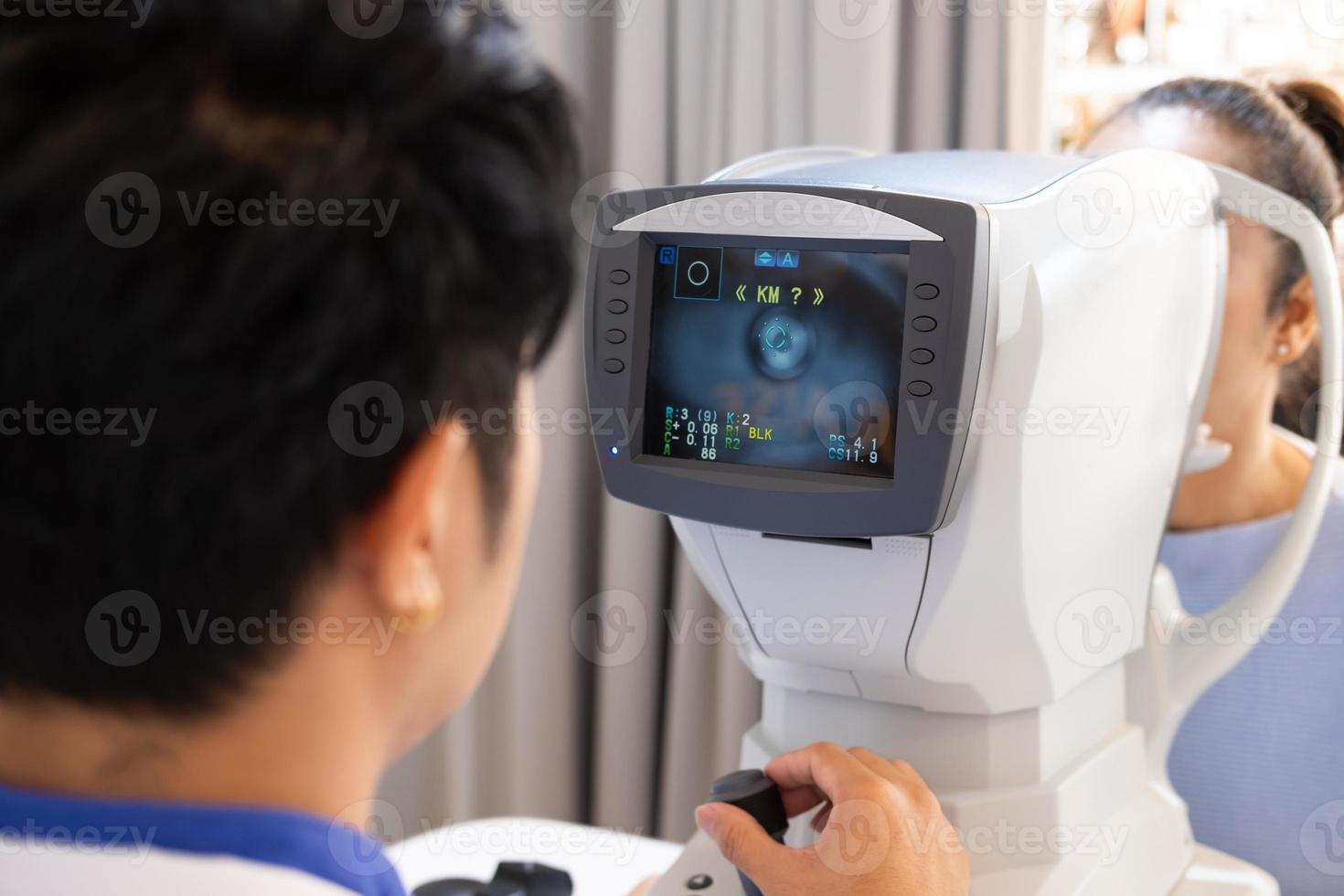 Selective focus at screen of Optometry equipment. While optometrist using subjective refraction to  examine eye visual system of elder patient women with professional machine before made glasses. photo