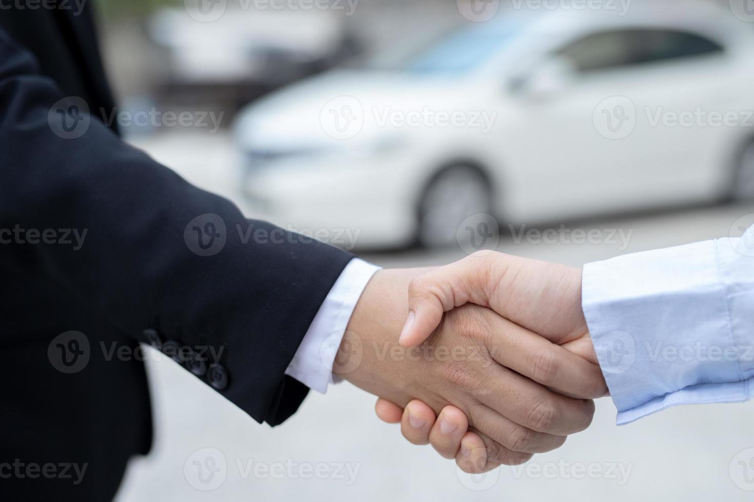 el vendedor lleva las llaves del auto entregadas al cliente en la sala de exposición con una oferta de bajo interés. promoción especial foto