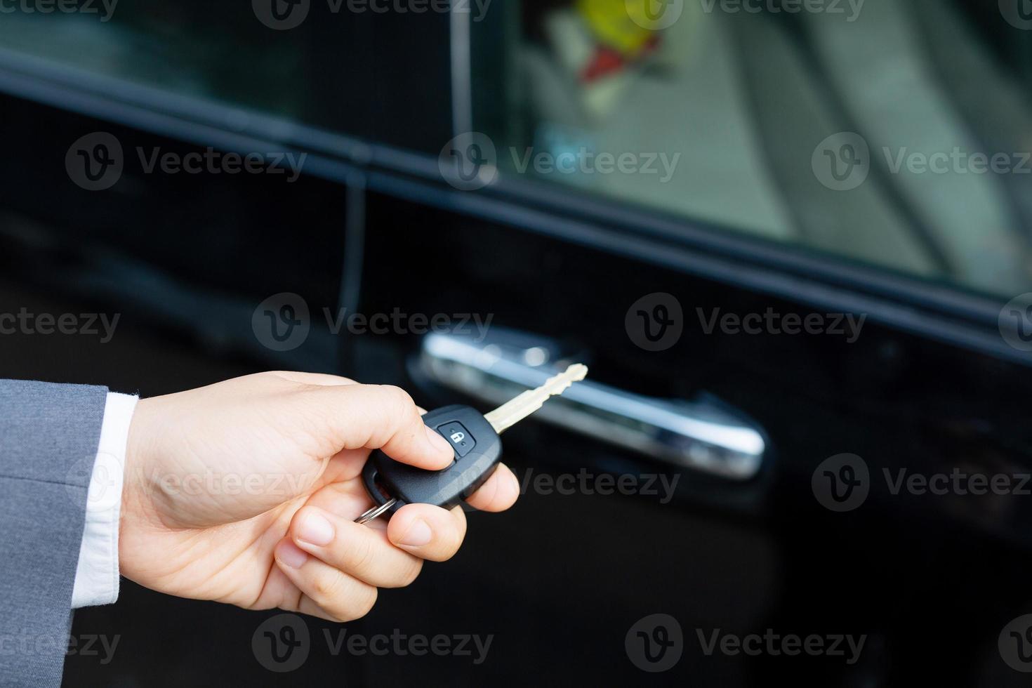 Salesman is carrying the car keys delivered to the customer at the showroom with a low interest offer. Special promotion photo