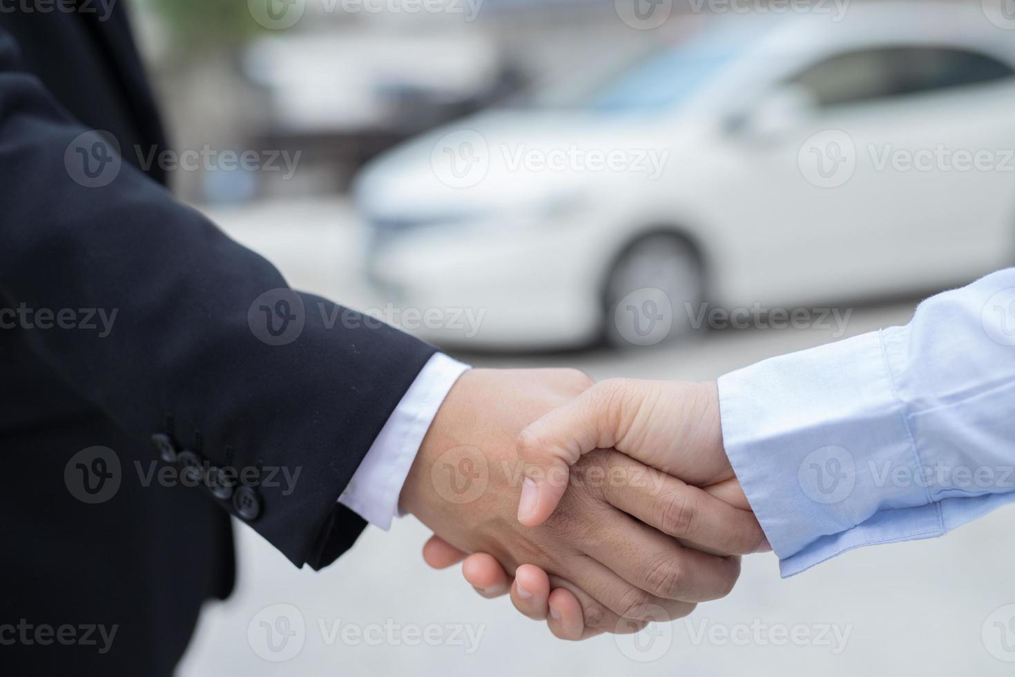 Salesman is carrying the car keys delivered to the customer at the showroom with a low interest offer. Special promotion photo