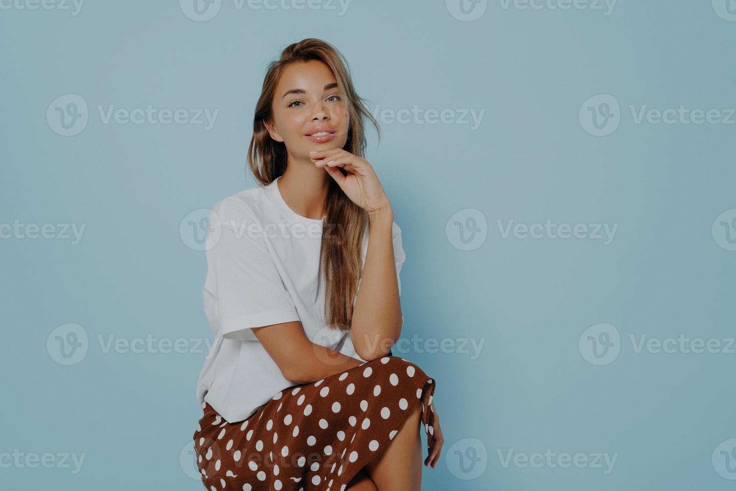 Young woman in stylish outfit on light blue background photo