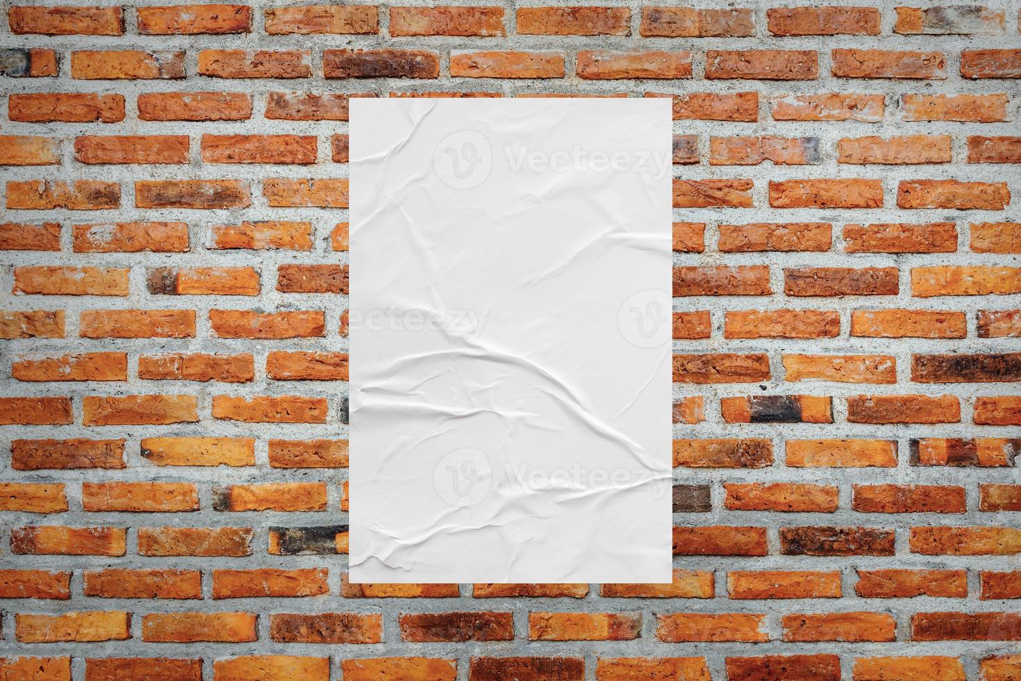 Blank white wheatpaste glued paper poster mockup on brick wall background photo