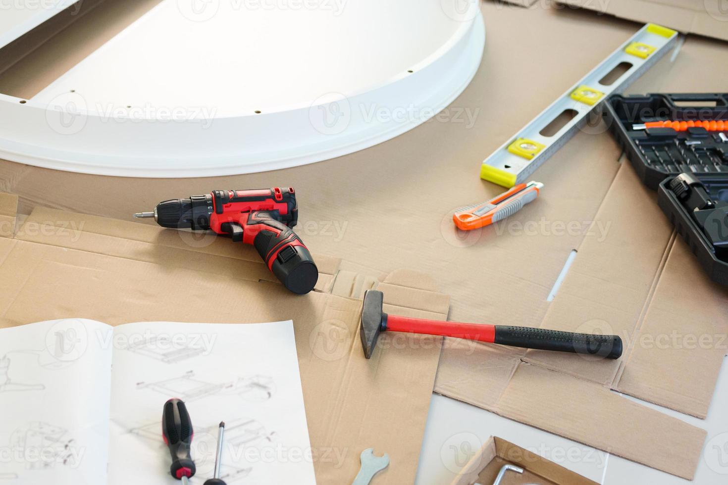 Cordless screwdriver and tool on cardboard paper assembly furniture concept photo