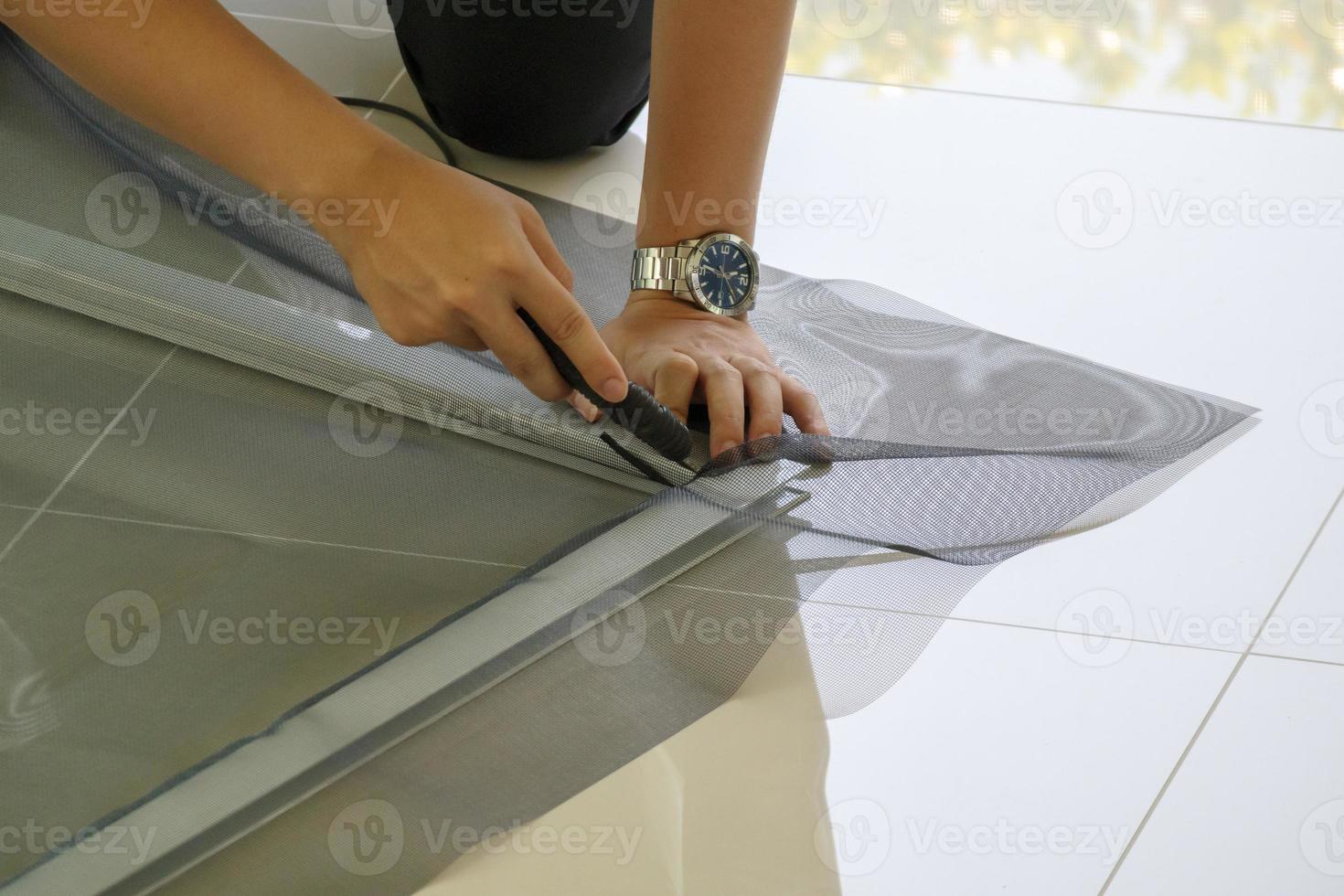 man install mosquito net wire screen on house window protection against insect photo