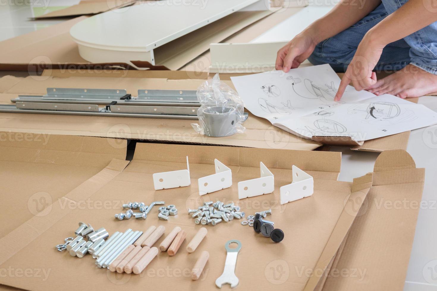 Man assembling white round table furniture at home photo