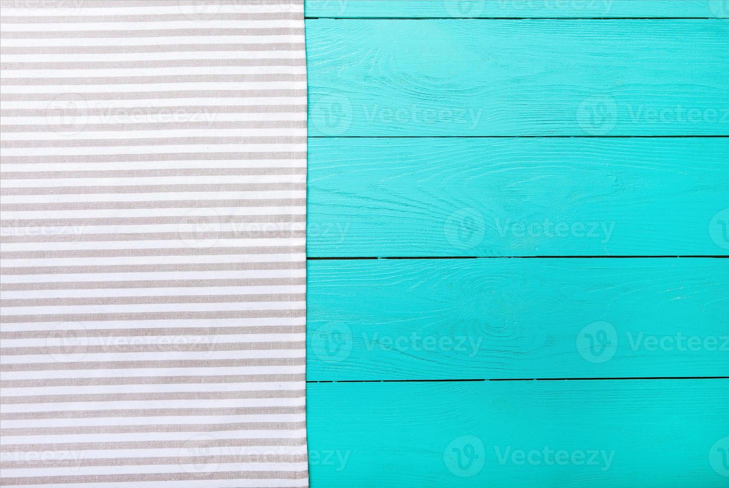 Striped gray and white material on blue wooden background. Top view and copy space. Mock up photo