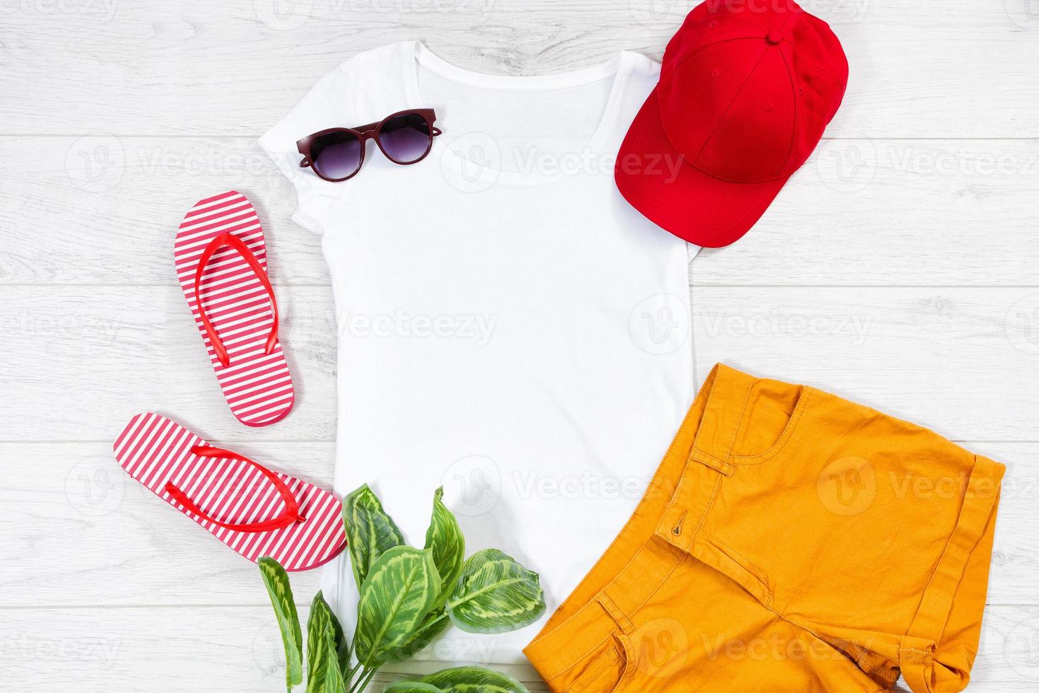 White female t shirt flip flops mock up flat lay on wooden background. Top view and copy space. Mockup t-shirt and summertime. Template blank shirt. Yellow hat photo