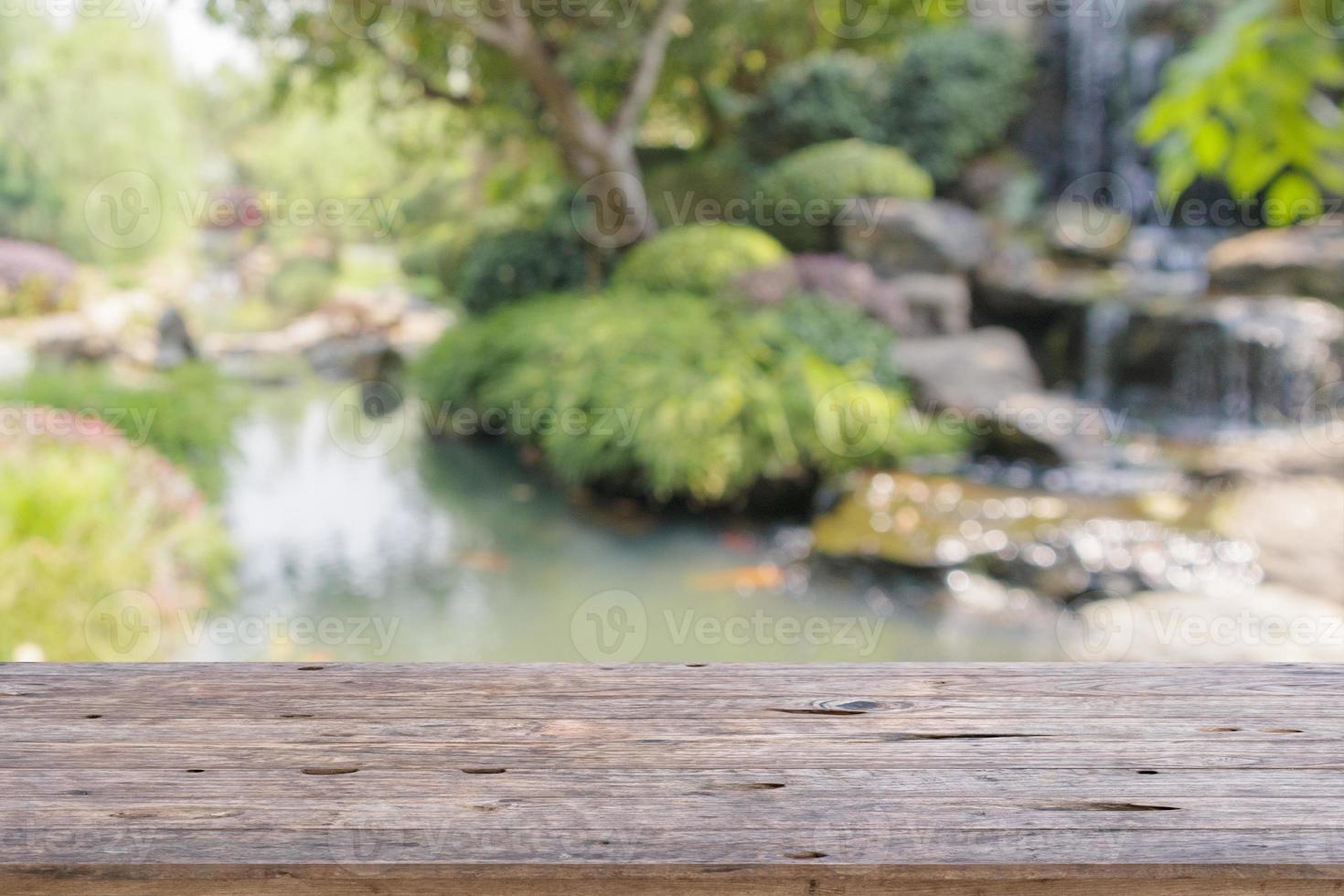 Empty wood table top with abstract blur park garden pond background photo