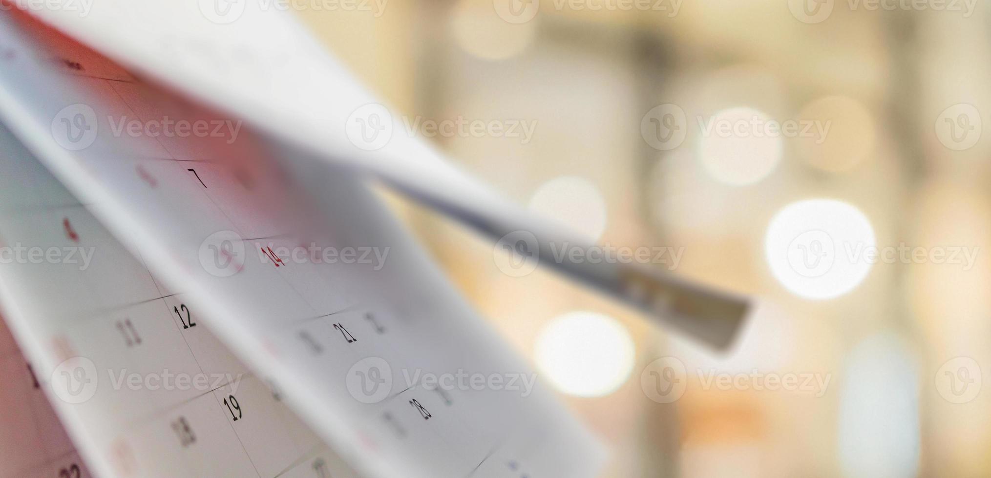 Close up white paper desk calendar with blurred bokeh background appointment and business meeting concept photo