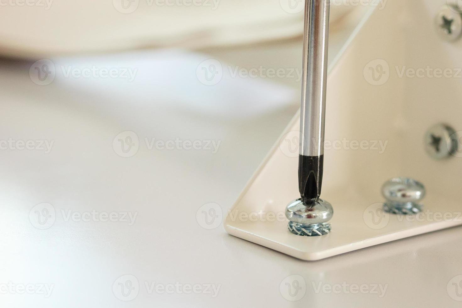 Asian man assembling white table furniture at home photo