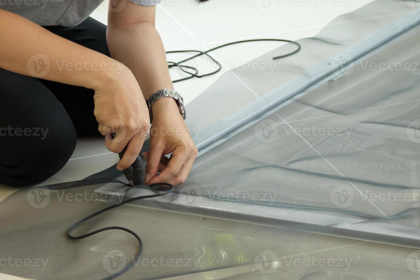 man install mosquito net wire screen on house window protection against insect photo
