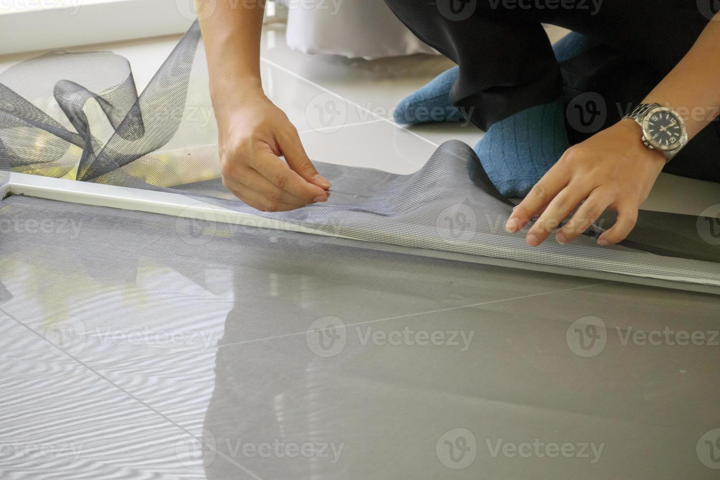 man install mosquito net wire screen on house window protection against insect photo