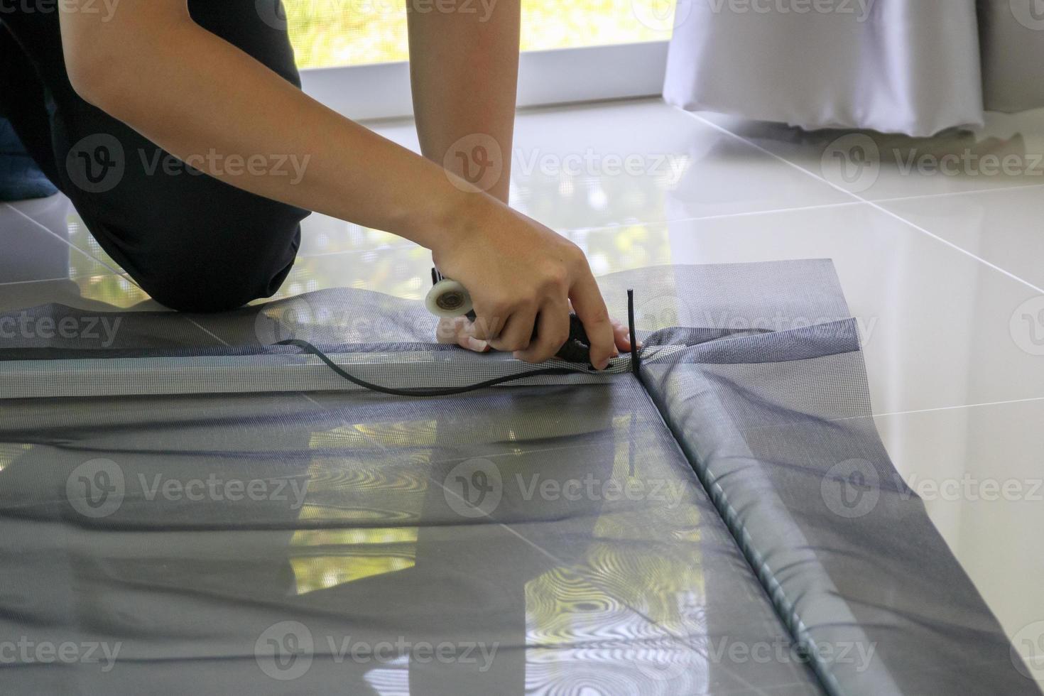 man install mosquito net wire screen on house window protection against insect photo