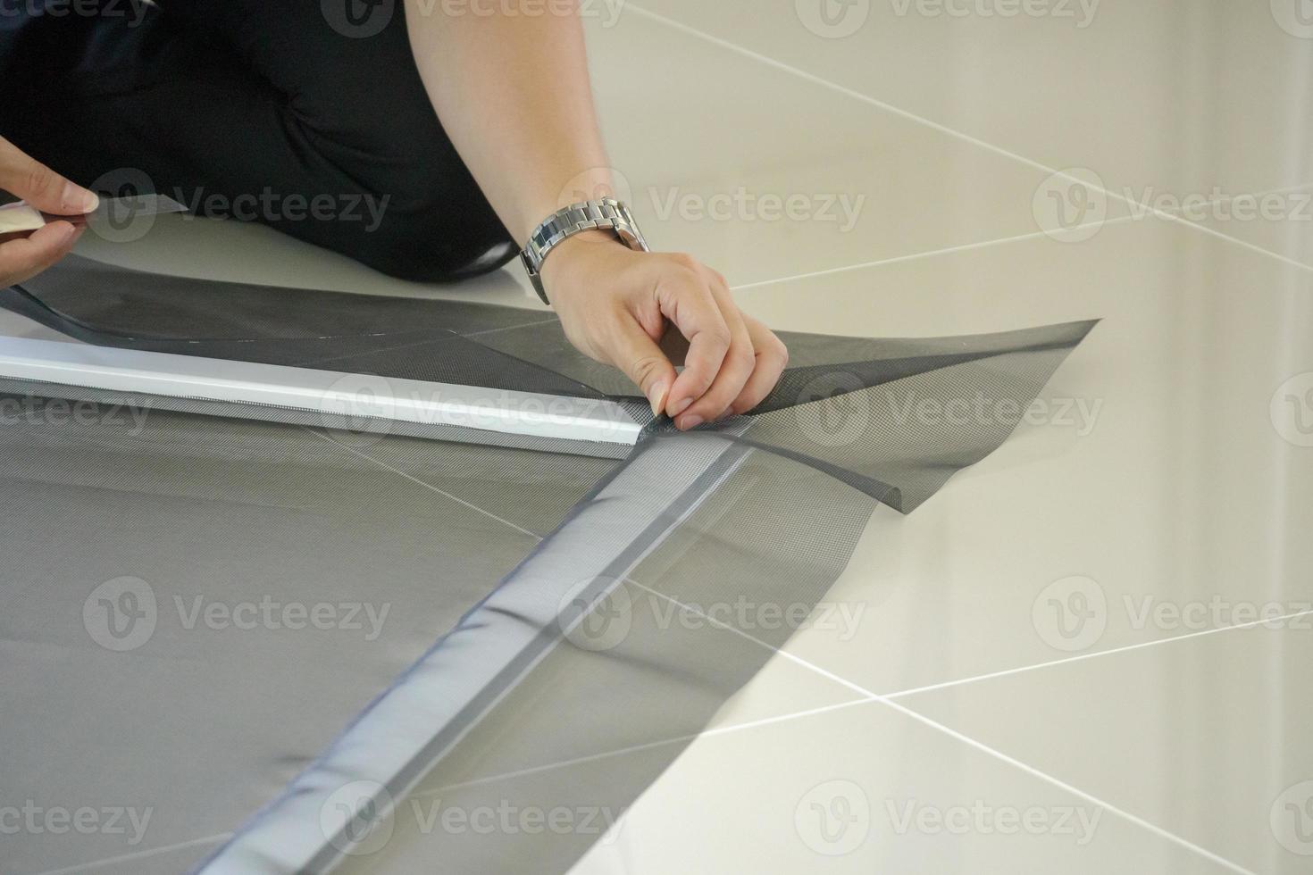 man install mosquito net wire screen on house window protection against insect photo