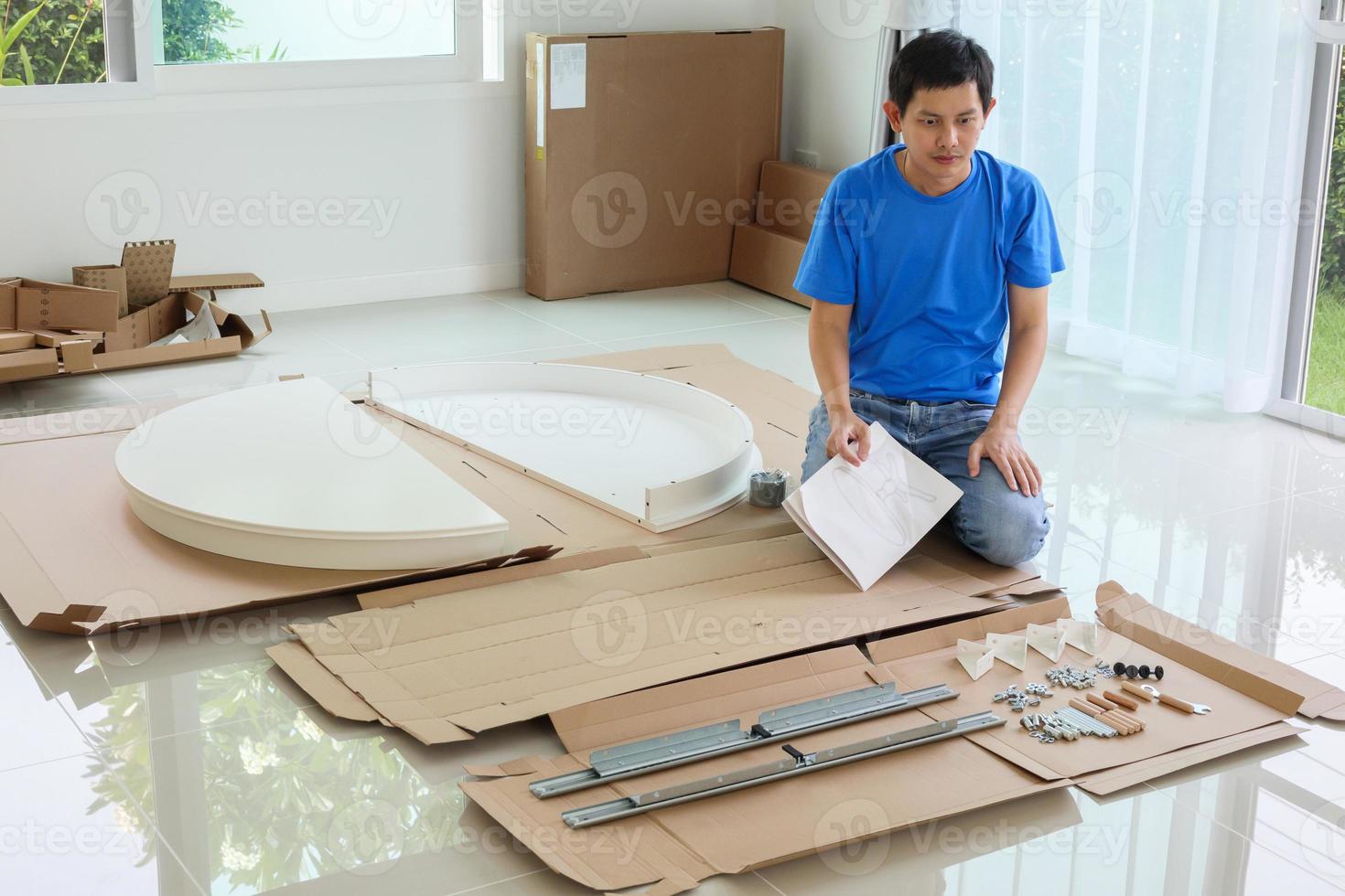 Man assembling white round table furniture at home photo
