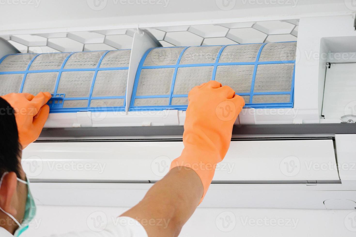 Asian man cleaning air conditioner dirty filter photo