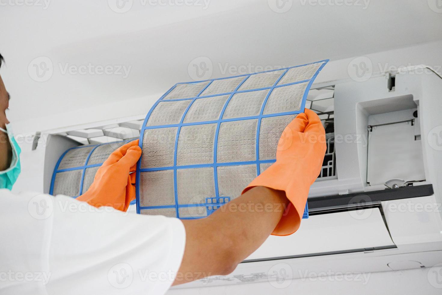 Asian man cleaning air conditioner dirty filter photo