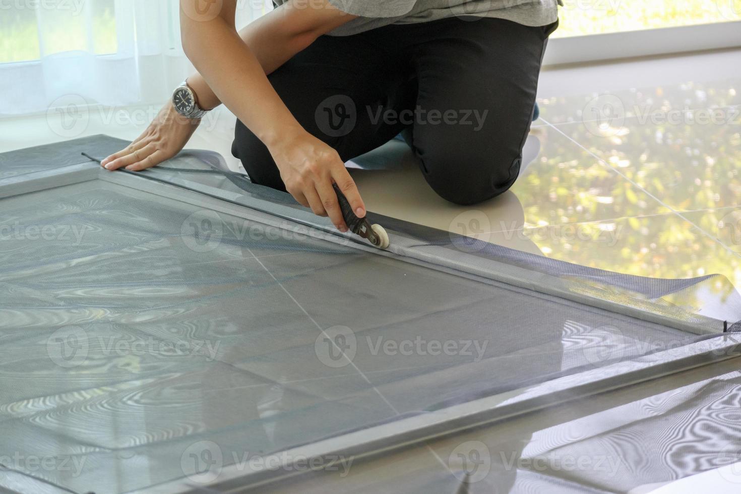 man install mosquito net wire screen on house window protection against insect photo