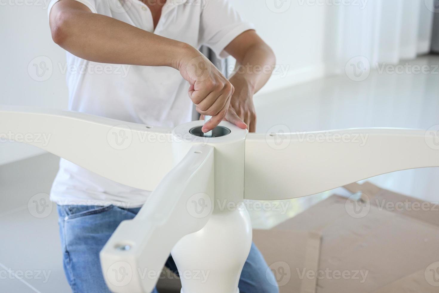 Asian man assembling white table furniture at home photo