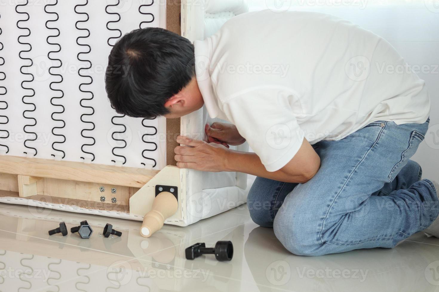 Man assembling sofa furniture at home photo