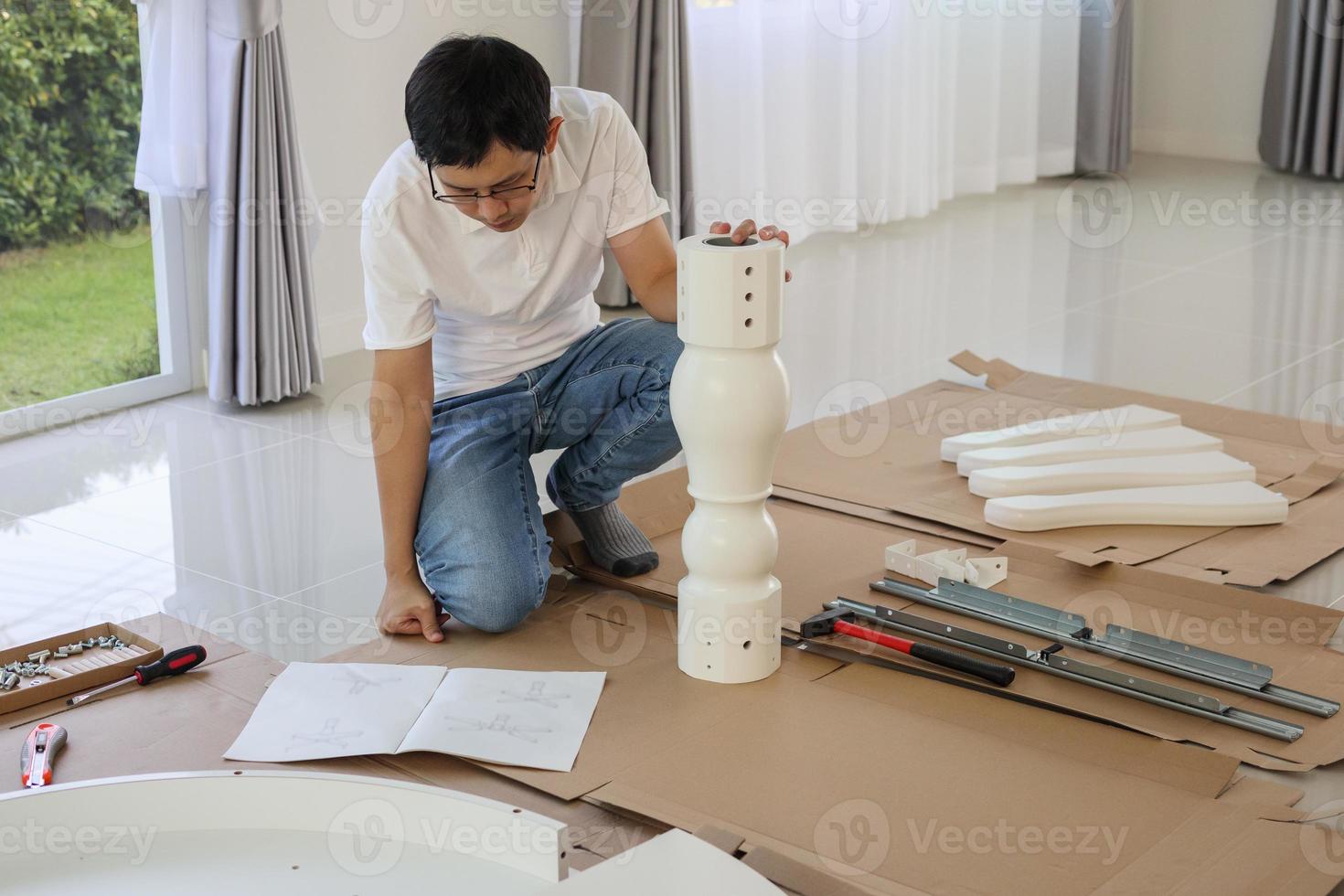 Man assembling white table furniture at home photo