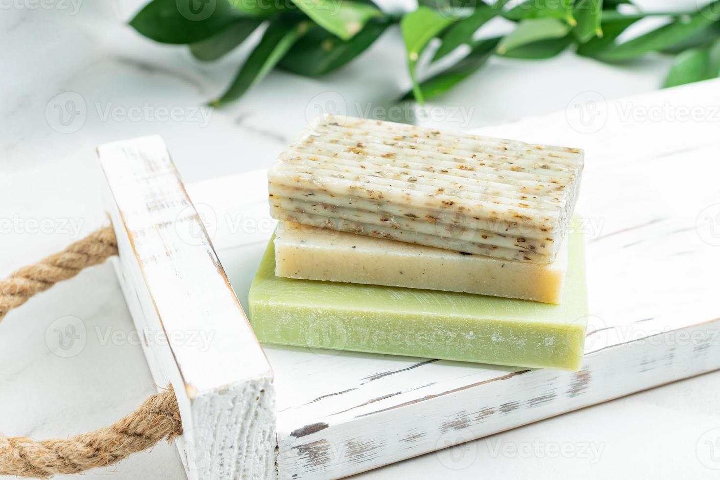 Tray with natural handmade soap on white table. Three different types for soap for exfoliation, cleansing and moisturizing of the skin. photo