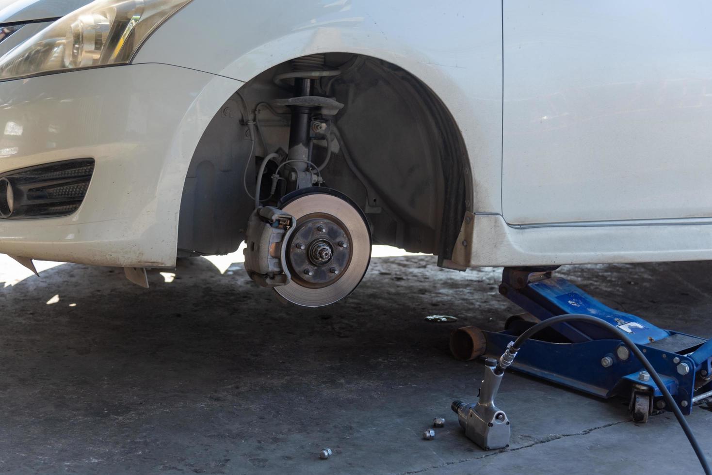 Change a car tire caused by a flat tire by using a jack to lift the car. photo