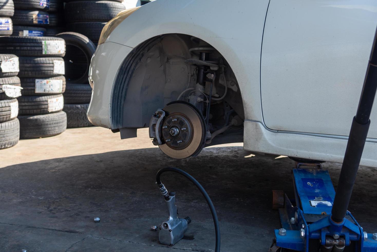 Change a car tire caused by a flat tire by using a jack to lift the car. photo