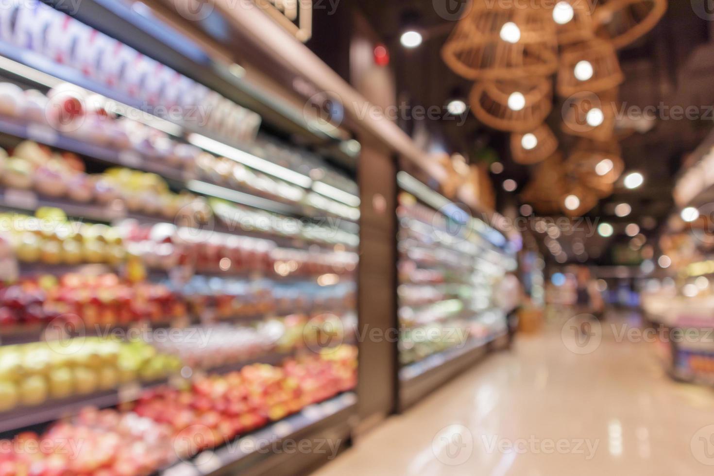 Fresh fruits and vegetables shelves in grocery store blurred background photo