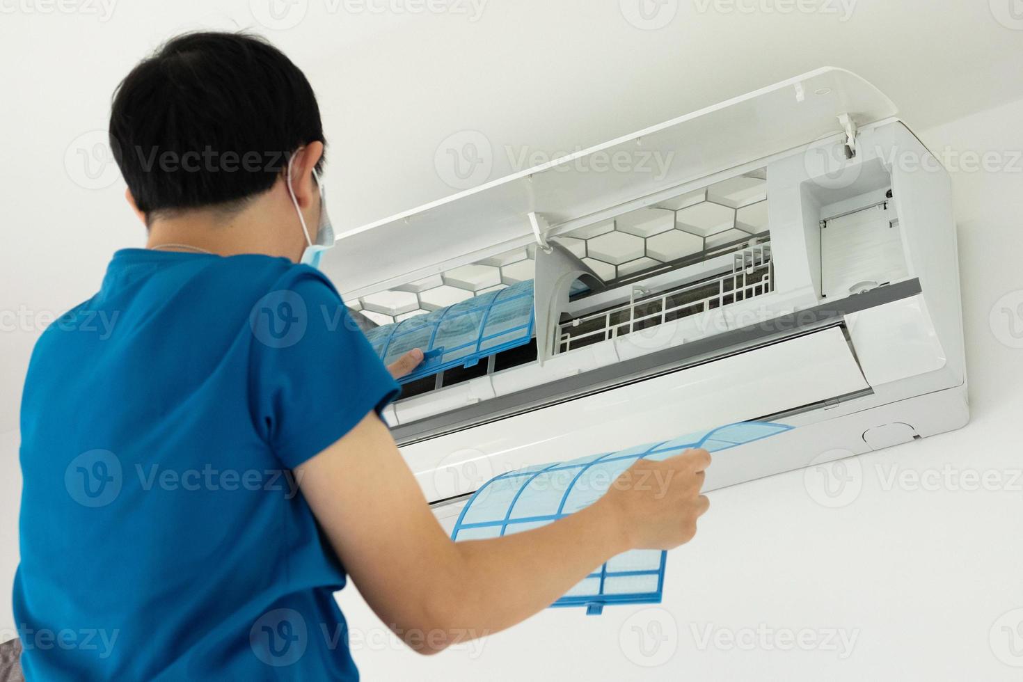 Asian man cleaning air conditioner filter photo