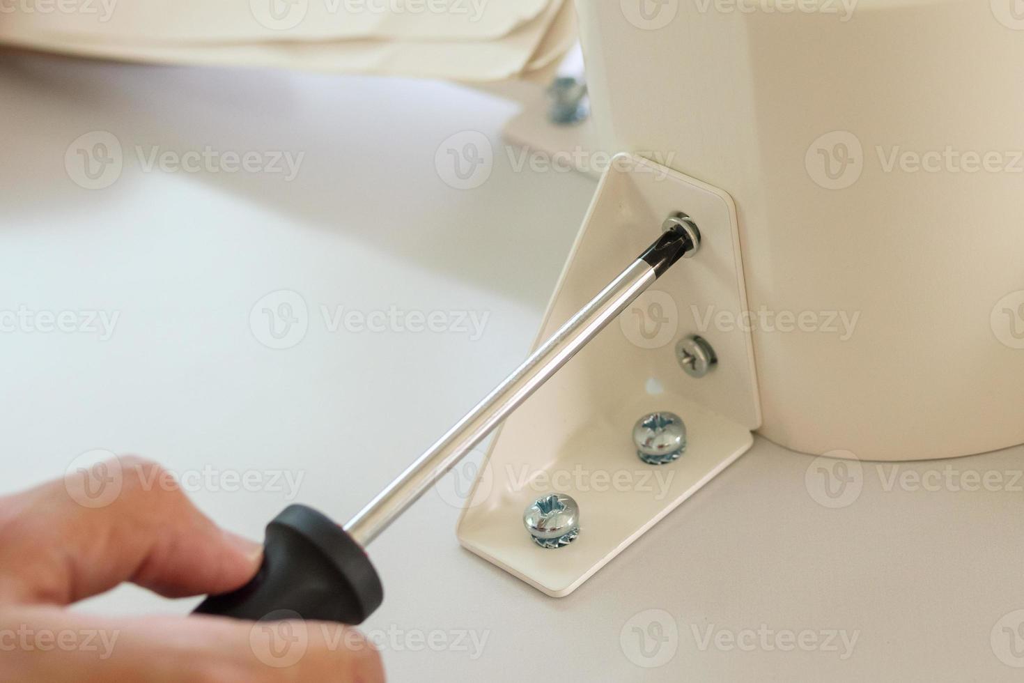 Asian man assembling white table furniture at home photo