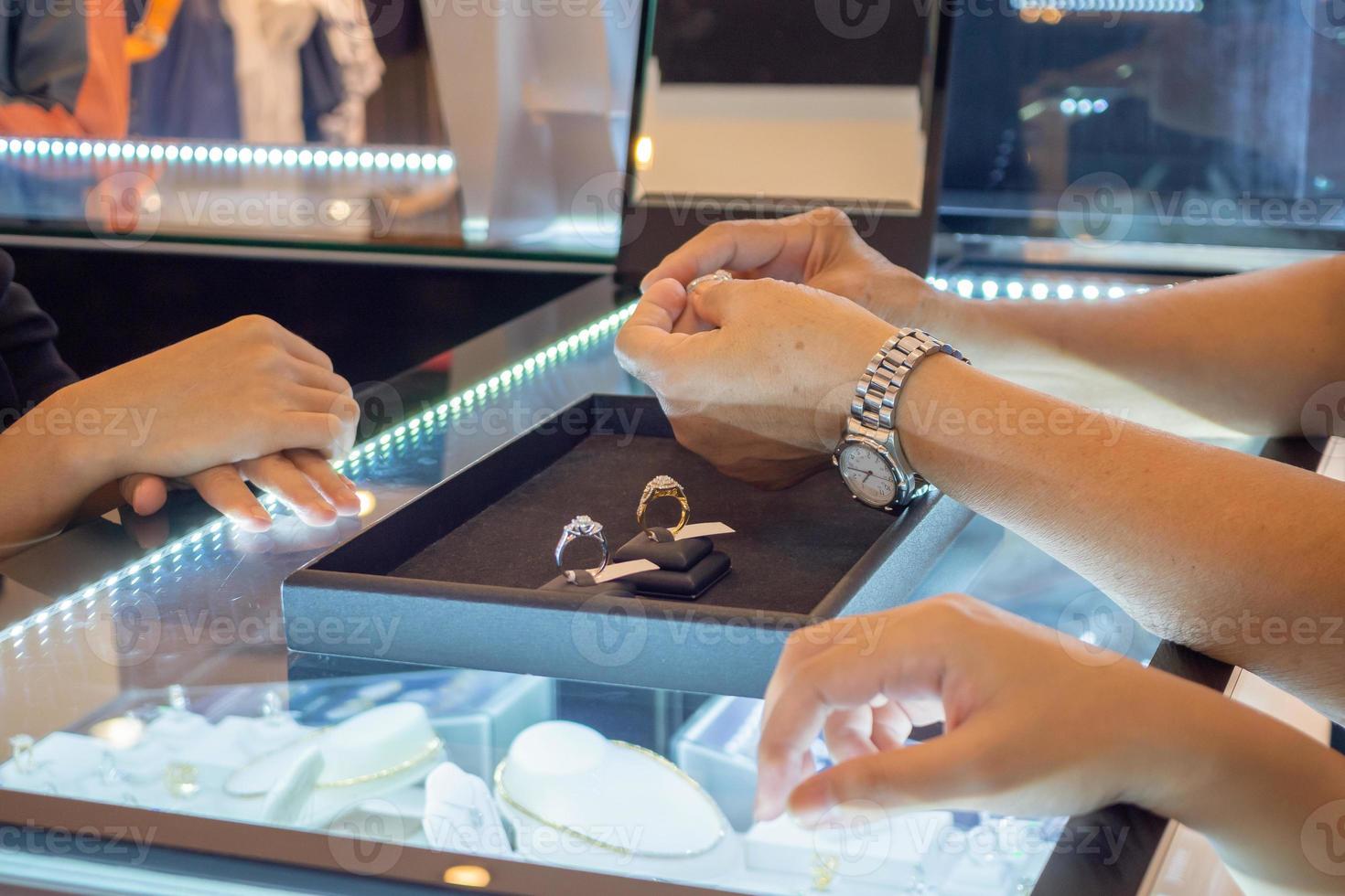 woman choosing diamond rings at jewelry store shop photo
