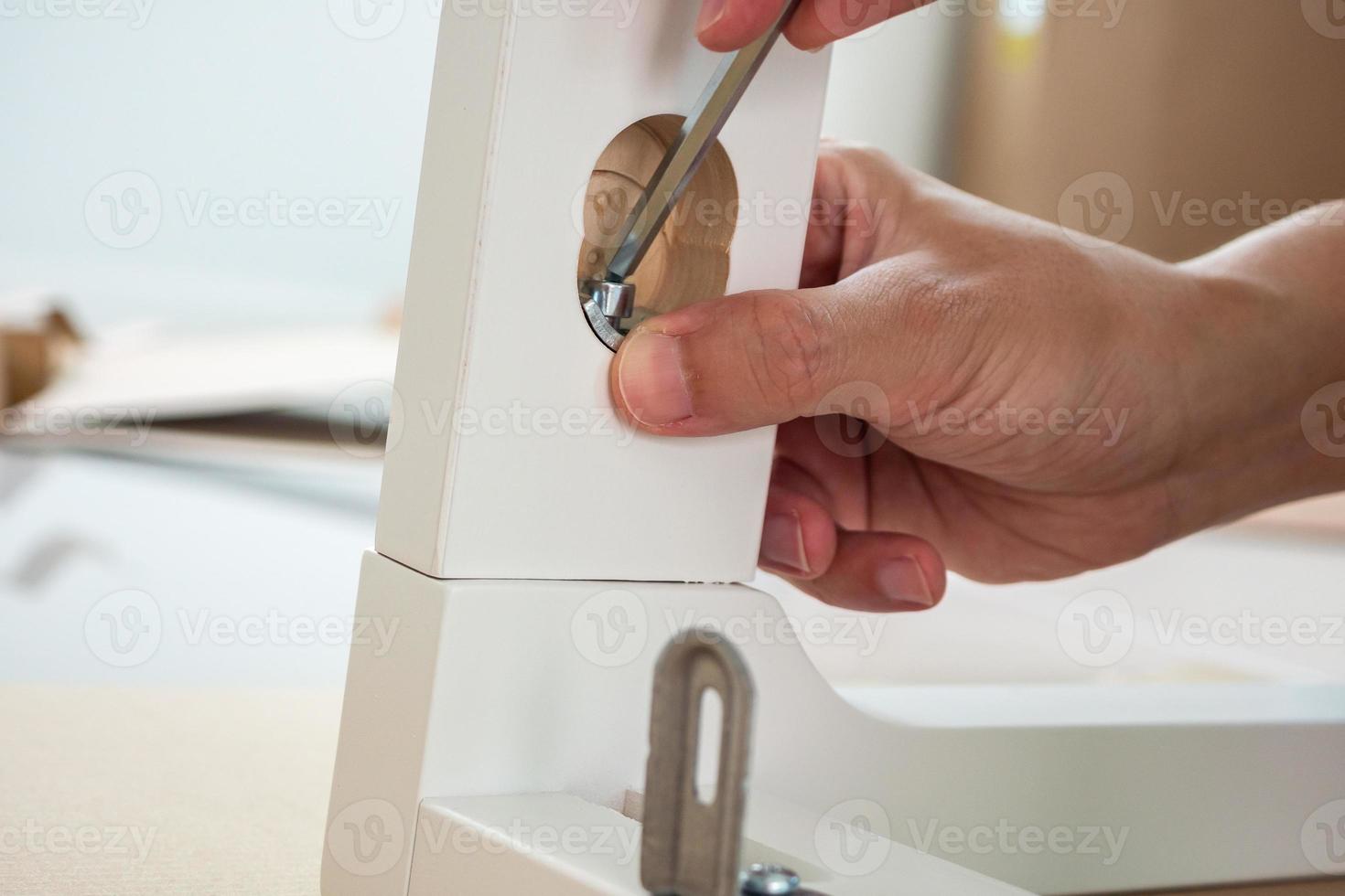 Man assembling white chair furniture at home photo