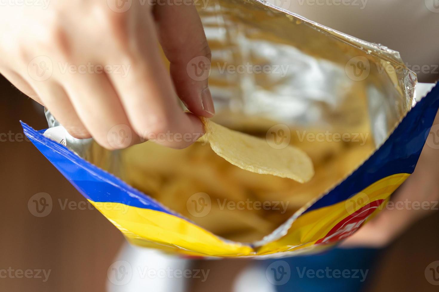 Hand hold potato chips with snack bag photo