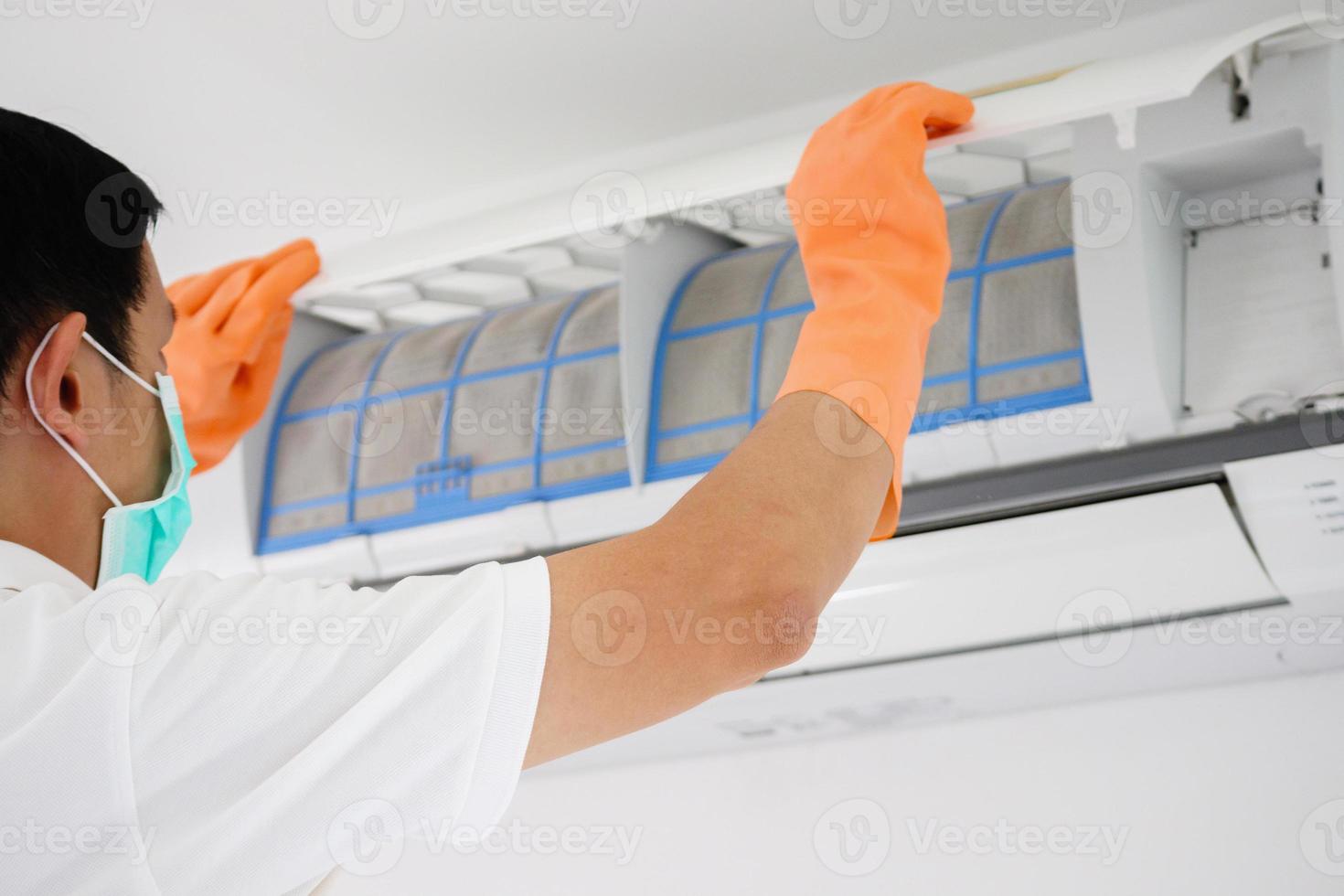 Asian man cleaning air conditioner dirty filter photo