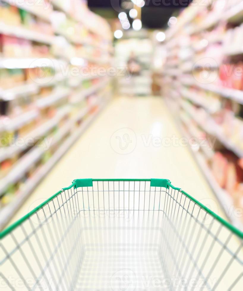 carrito de compras verde vacío en el pasillo del supermercado foto