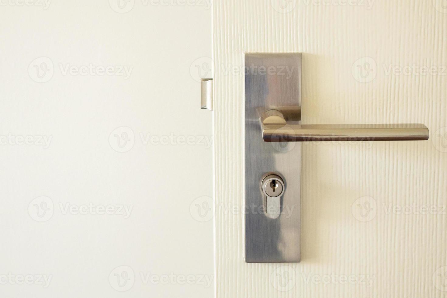 Modern door handle with keyhole on white door 13009068 Stock Photo at