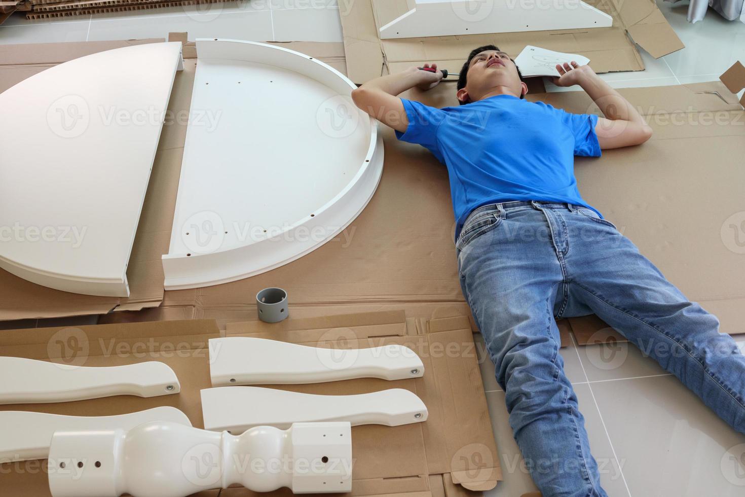 Man assembling white round table furniture at home photo