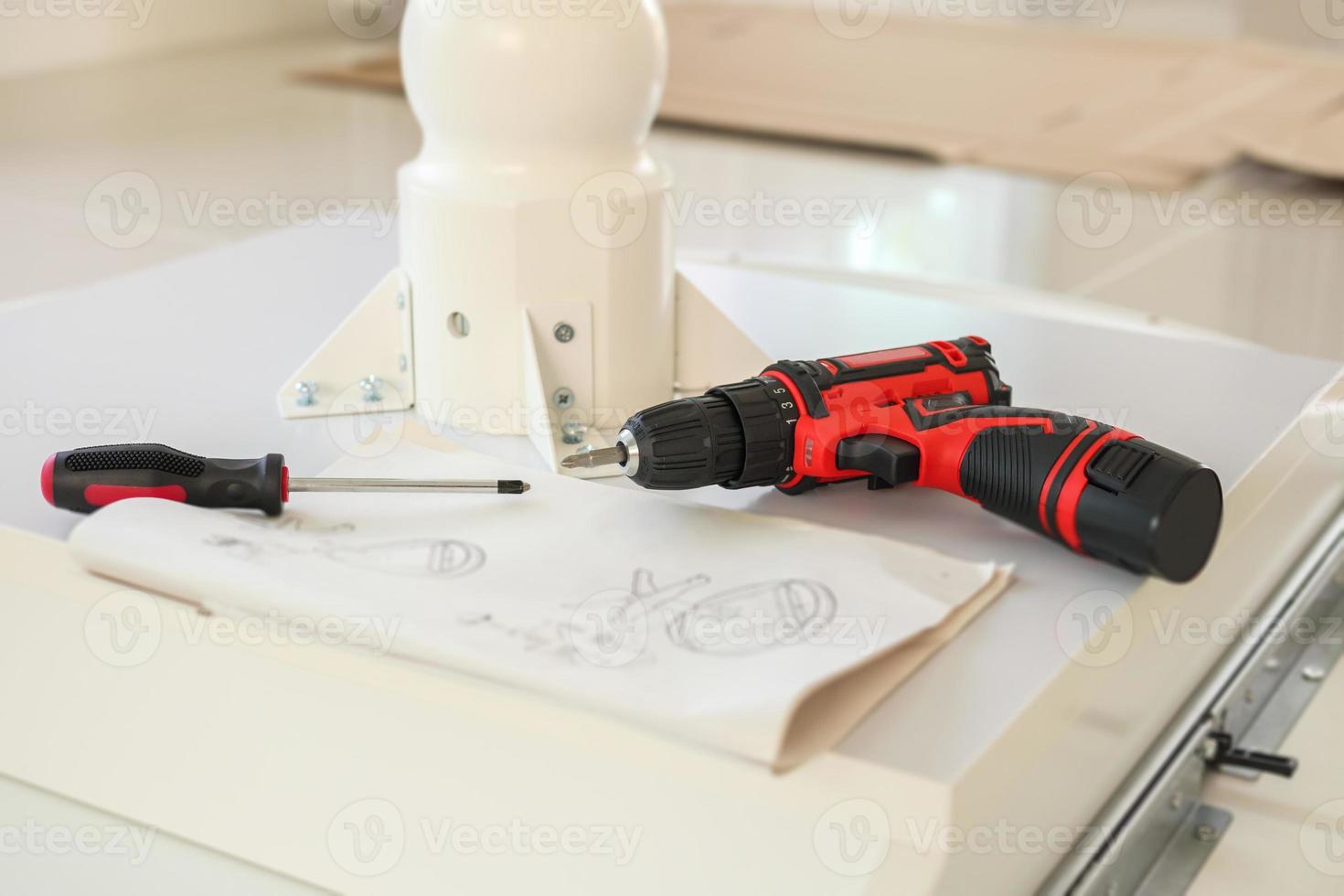 Cordless screwdriver on wood table assembly furniture concept photo