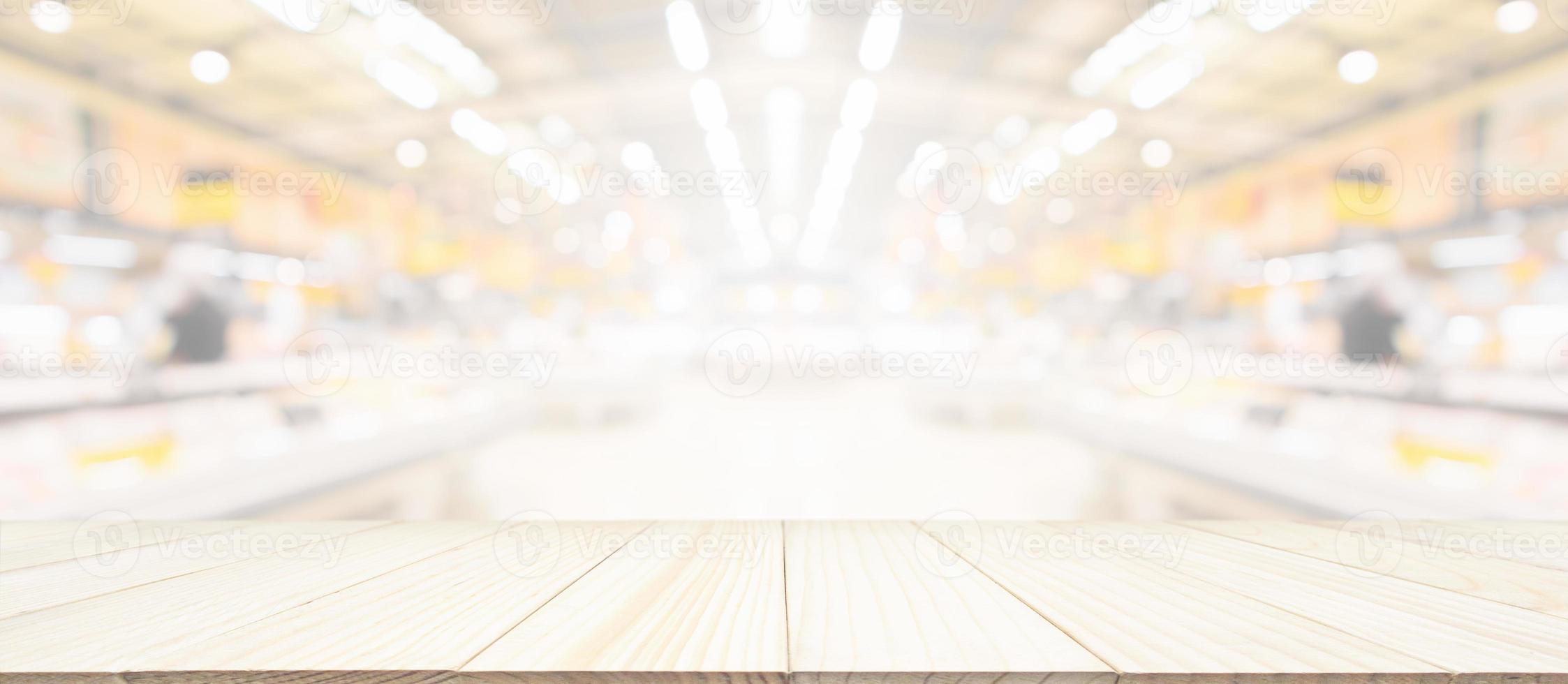 Wood table top with supermarket grocery store blurred background with bokeh light for product display photo
