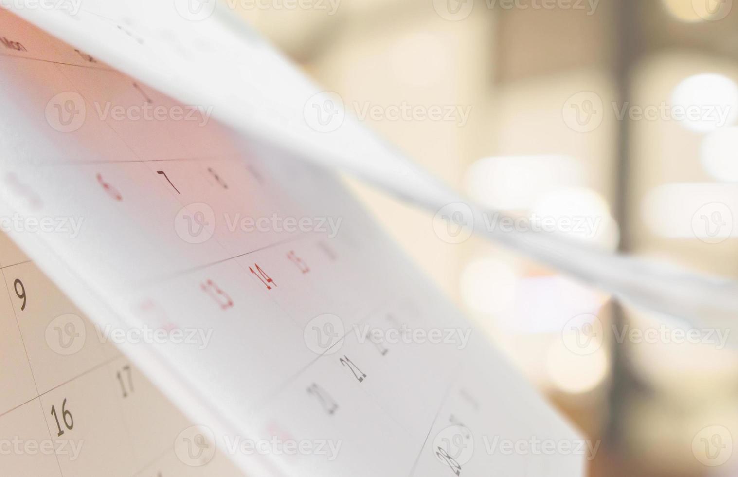 Close up white paper desk calendar with blurred bokeh background appointment and business meeting concept photo