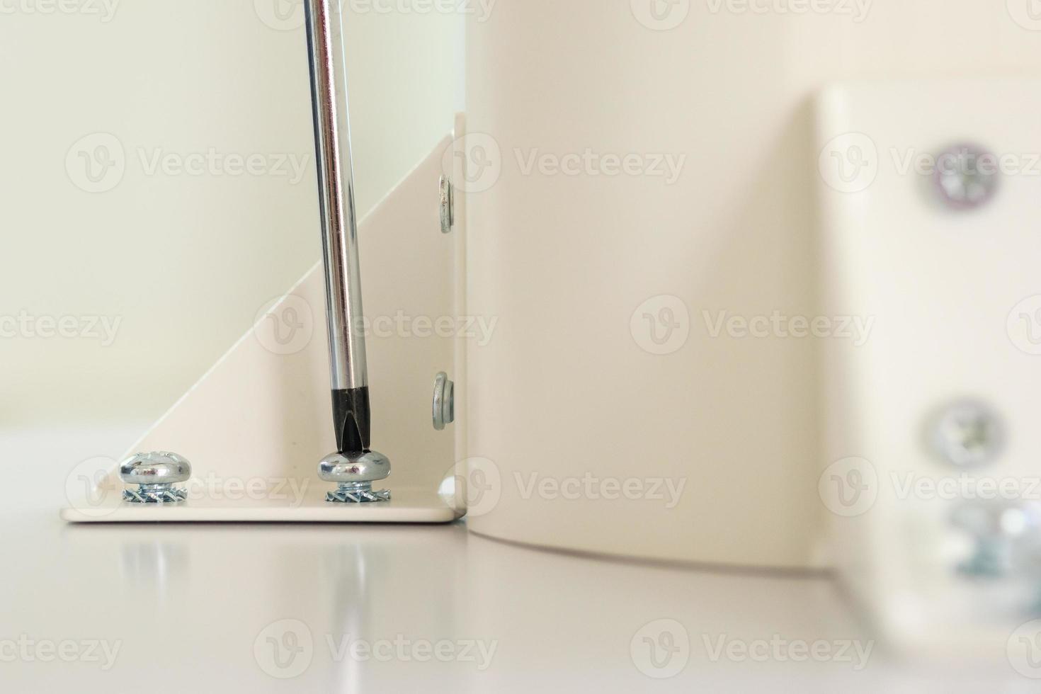 Asian man assembling white table furniture at home photo