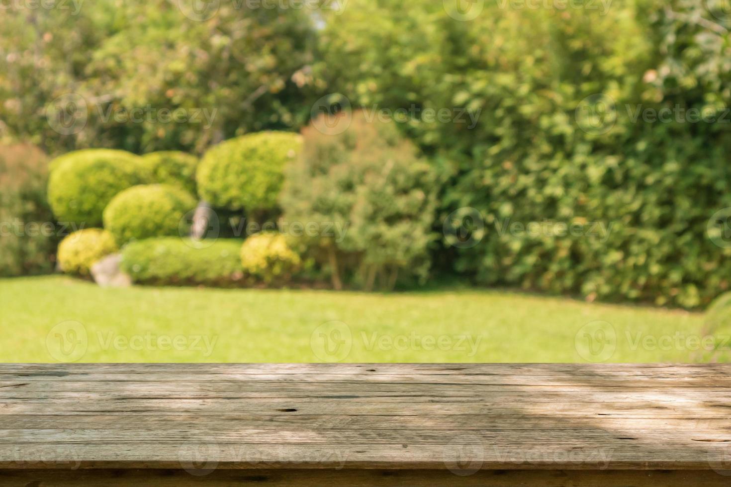 Empty wood table top with abstract blur park garden background photo