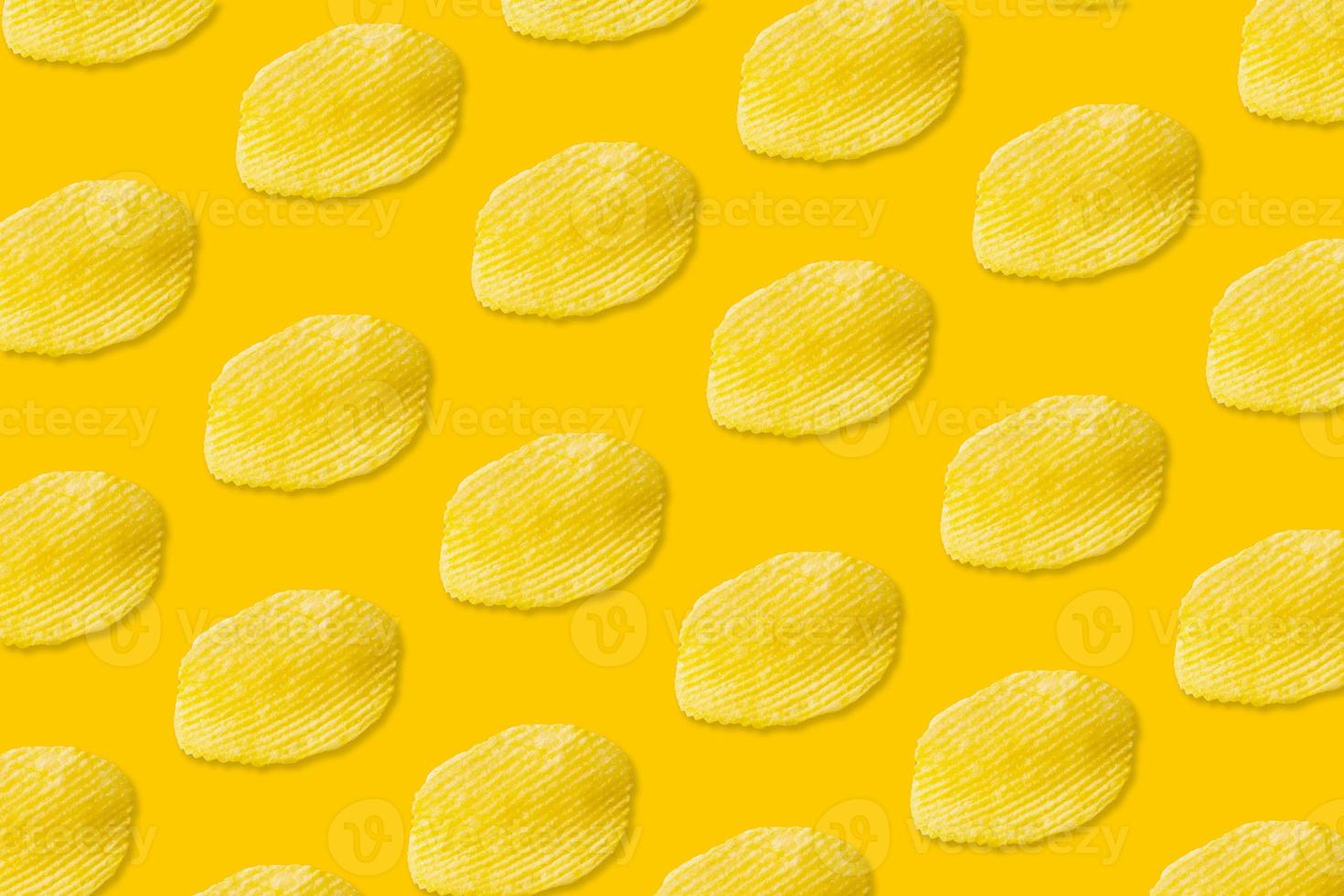 Potato chips pattern on yellow background top view flat lay photo