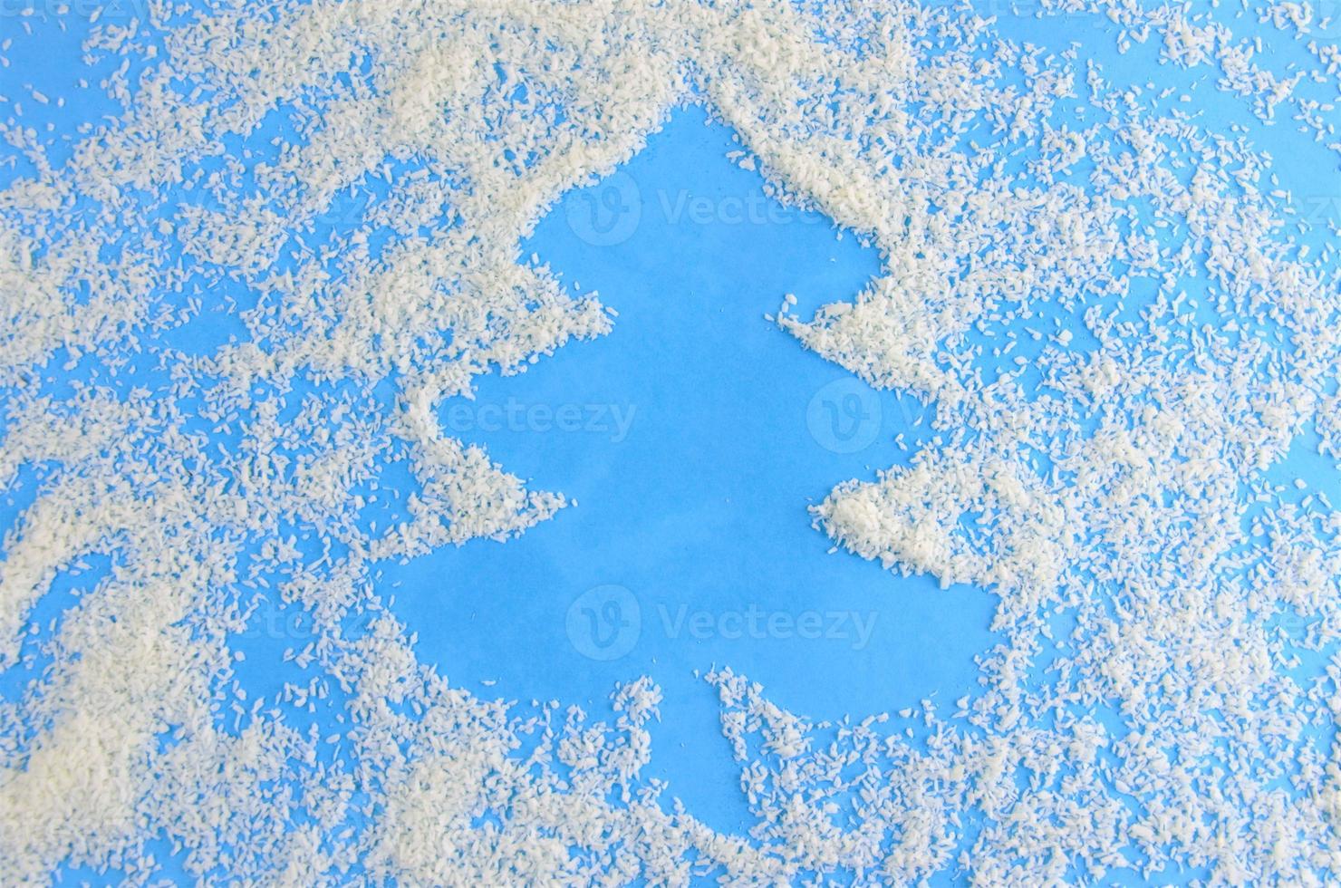 fondo azul navideño con chips de coco, un lugar para grabar en forma de árbol de navidad foto