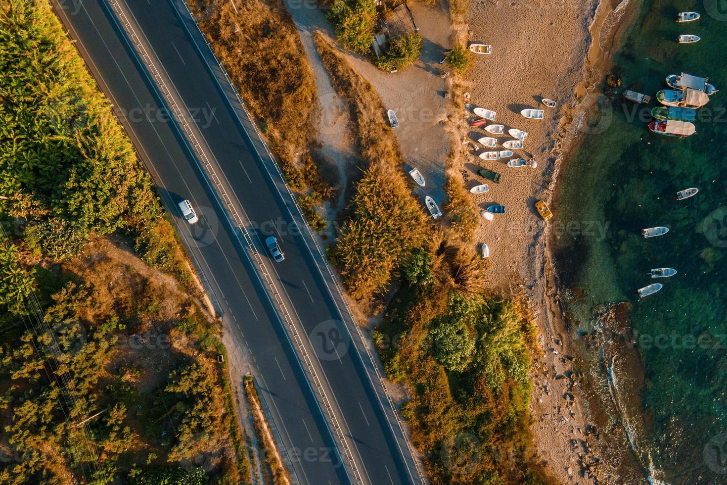 Aerial.road and Waves float to the rocky shore. photo
