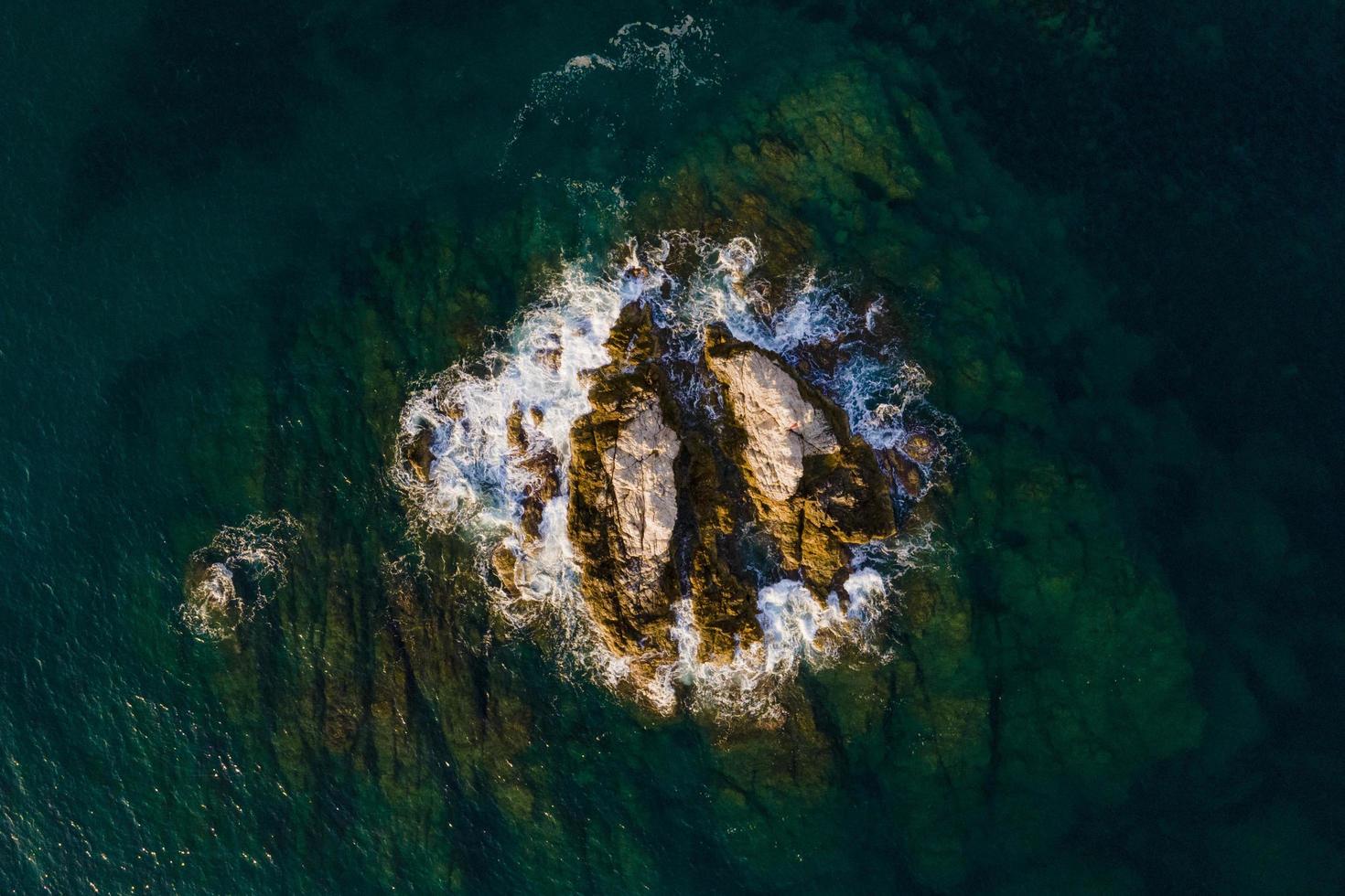 from the air. Waves float to the rocky shore. photo