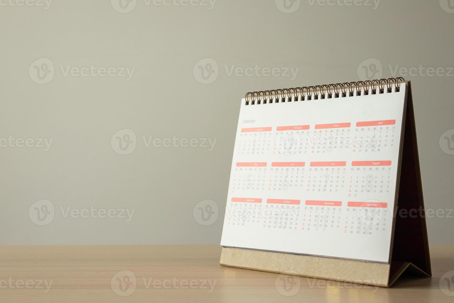 Calendar page close up on wood table with white wall background business planning appointment meeting concept photo