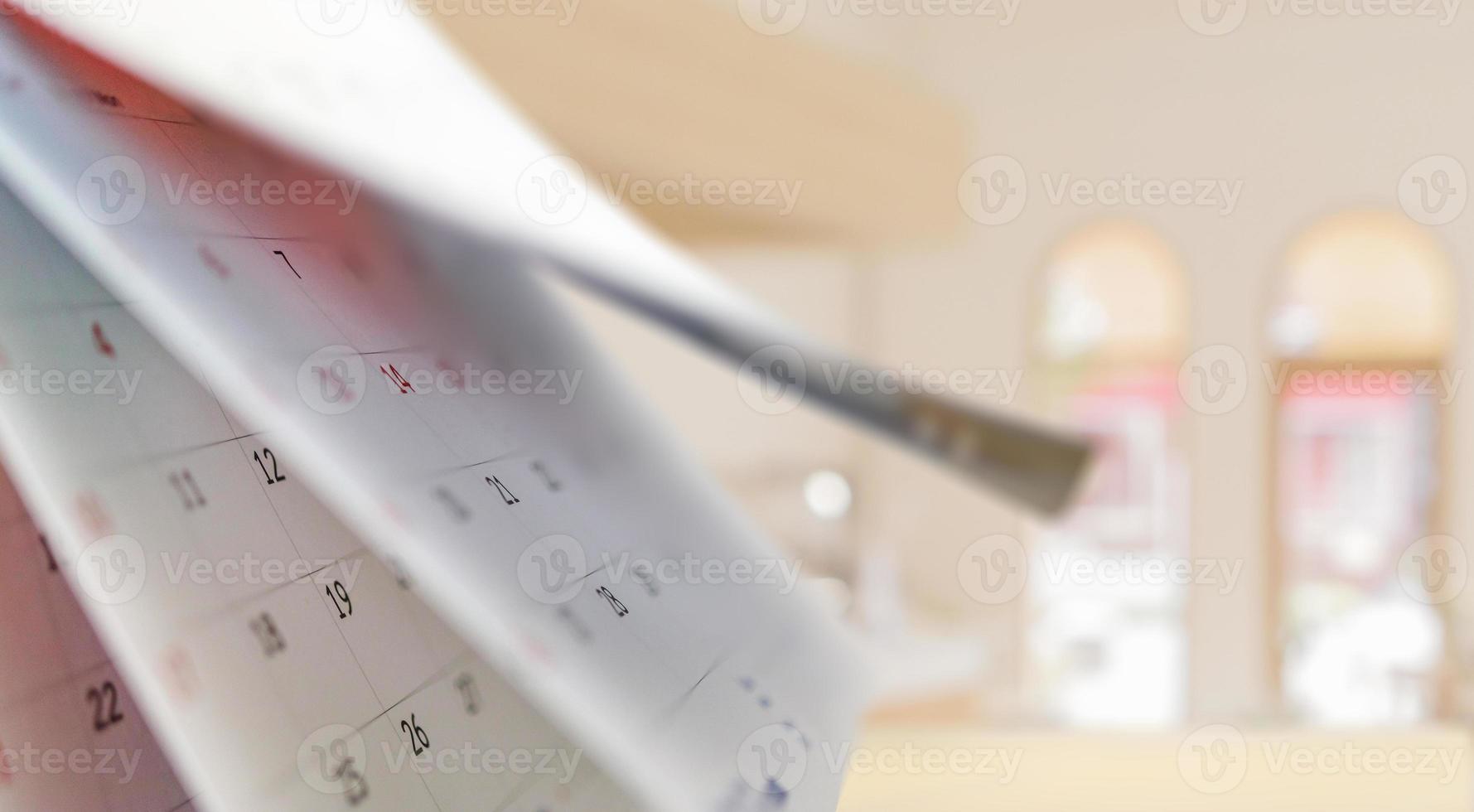 Close up white paper desk calendar with blurred bokeh background appointment and business meeting concept photo